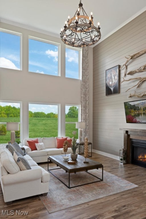 living room featuring a towering ceiling, an inviting chandelier, and dark hardwood / wood-style flooring