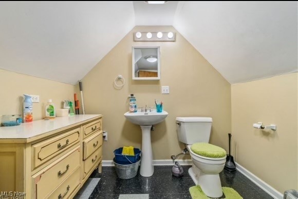 bathroom featuring lofted ceiling and toilet