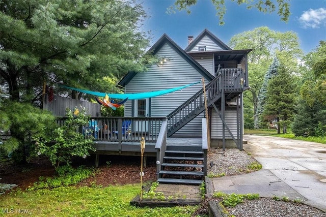 rear view of house with a chimney, central AC, stairway, and a wooden deck