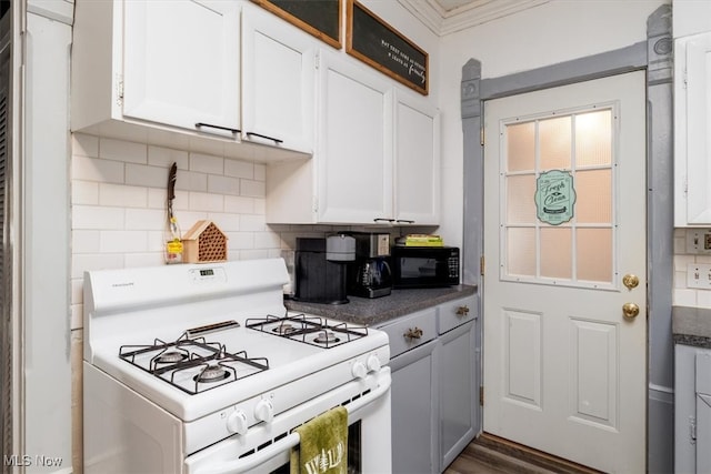 kitchen featuring white cabinetry, crown molding, backsplash, dark wood-type flooring, and white range with gas stovetop