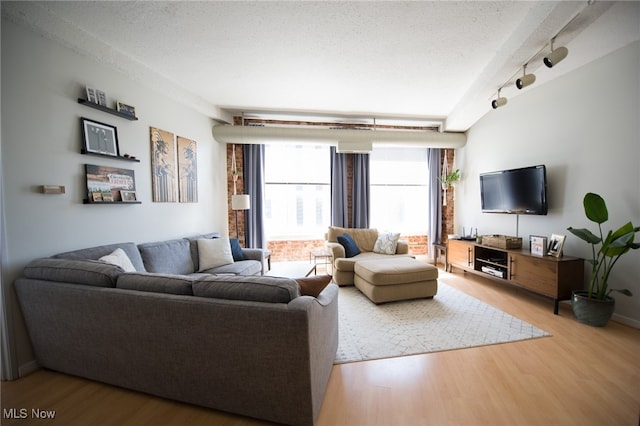 living room featuring rail lighting, a textured ceiling, and wood finished floors