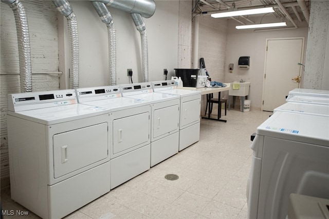 community laundry room with a sink, light floors, and washing machine and clothes dryer