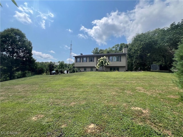 view of front of home featuring a chimney and a front lawn