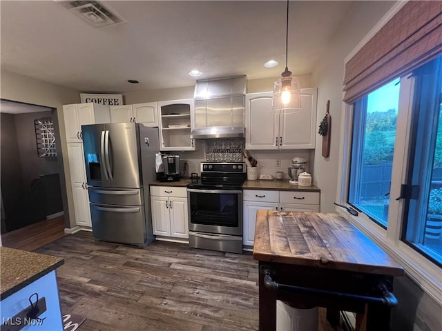 kitchen featuring appliances with stainless steel finishes, white cabinets, dark wood-type flooring, and extractor fan