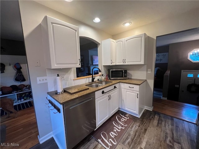 kitchen with white cabinetry, appliances with stainless steel finishes, dark wood finished floors, and a sink