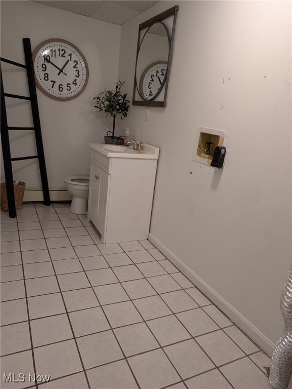 bathroom with tile patterned flooring, baseboards, vanity, and toilet