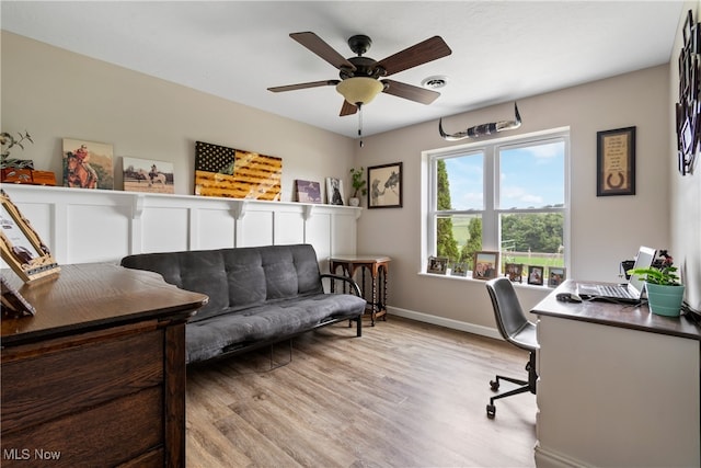 home office with light wood-type flooring and ceiling fan