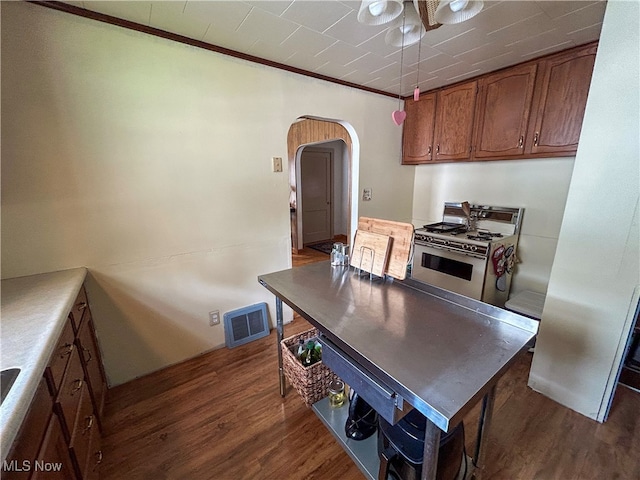 kitchen featuring ornamental molding, range with gas cooktop, and dark wood-type flooring