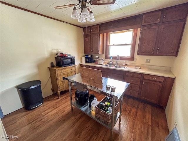 kitchen featuring wood-type flooring, ornamental molding, sink, and ceiling fan