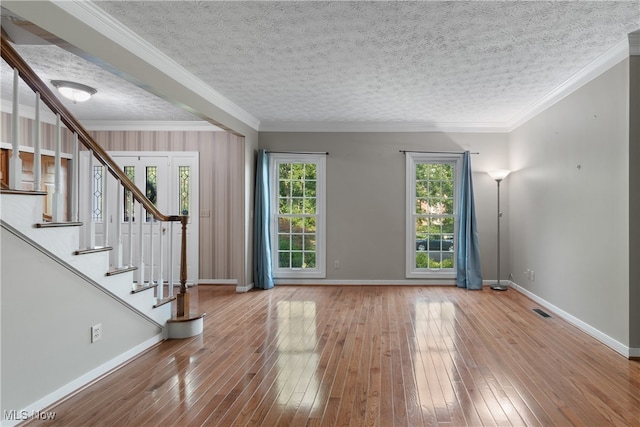 interior space featuring hardwood / wood-style floors, a healthy amount of sunlight, and crown molding