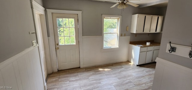 doorway with light tile patterned floors and ceiling fan