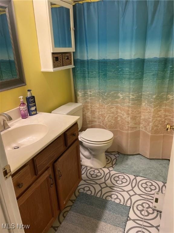 bathroom featuring tile patterned flooring, vanity, and toilet