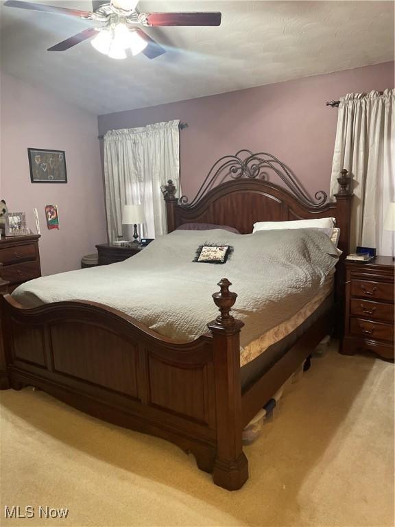 carpeted bedroom with lofted ceiling and ceiling fan