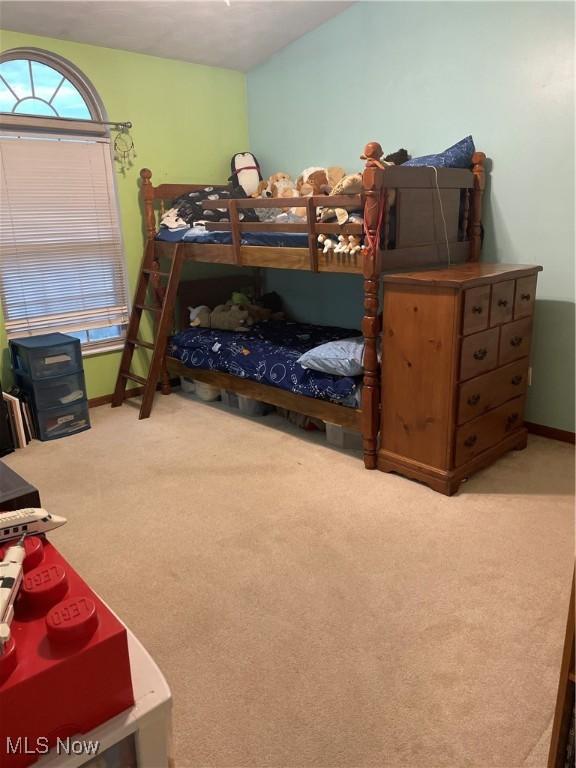 carpeted bedroom with vaulted ceiling