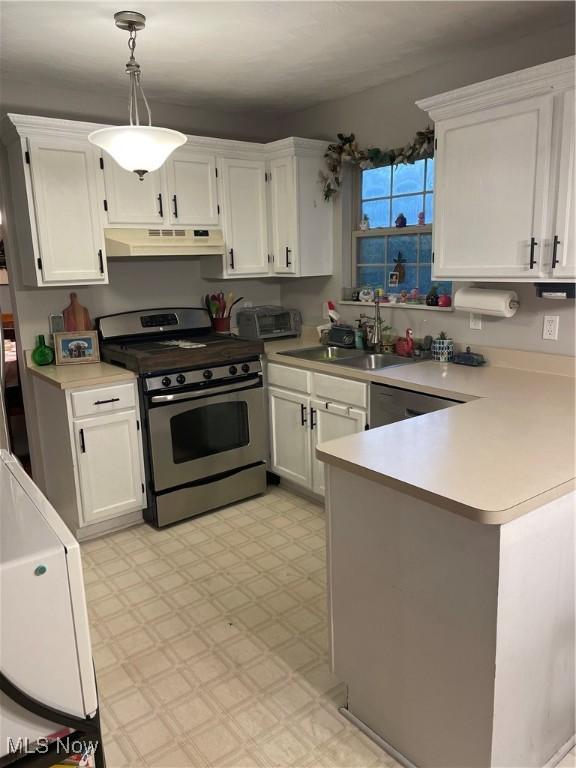 kitchen with pendant lighting, sink, white cabinets, stainless steel range with gas cooktop, and kitchen peninsula