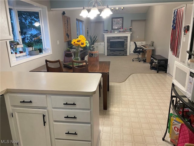 kitchen featuring hanging light fixtures, white cabinetry, and a notable chandelier