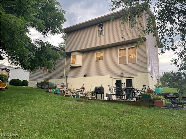 rear view of property with a yard and a patio