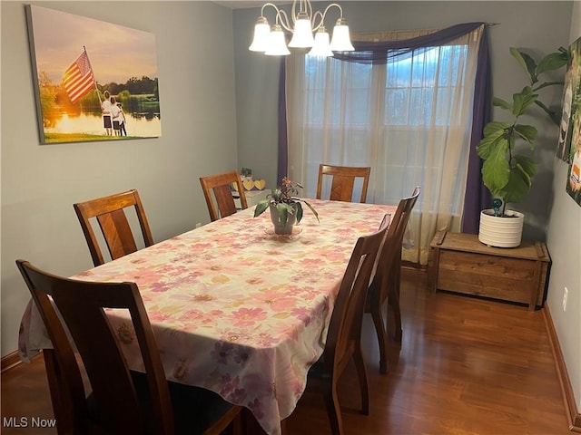 dining space with dark hardwood / wood-style flooring and a chandelier