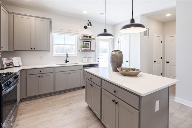 kitchen featuring a sink, black range with gas stovetop, and gray cabinets