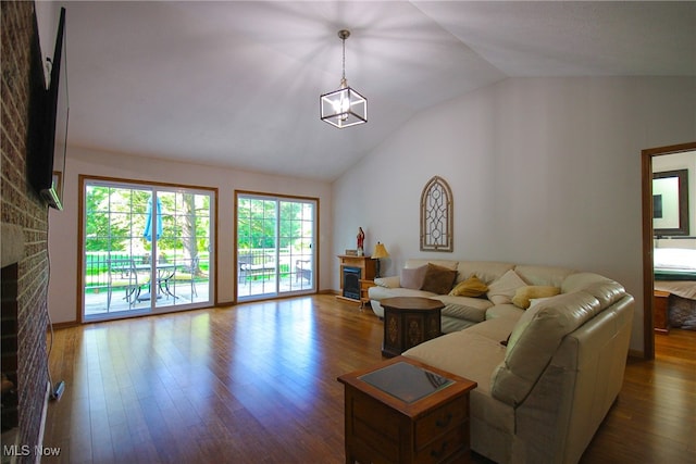 living room with a fireplace, lofted ceiling, and hardwood / wood-style floors