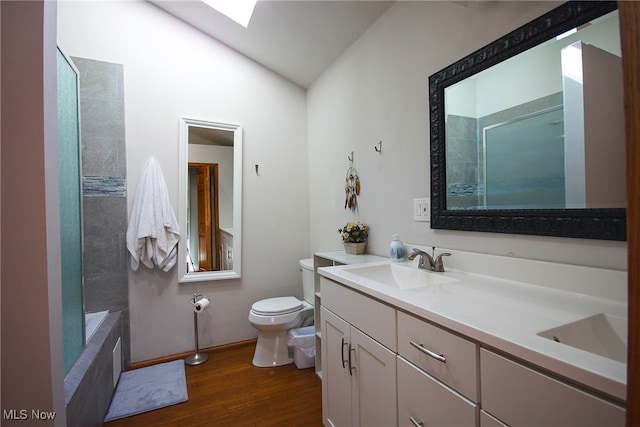 full bathroom with lofted ceiling, tiled shower / bath combo, toilet, vanity, and hardwood / wood-style flooring