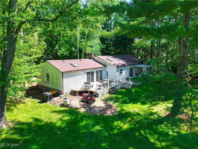 back of property with a yard and a wooden deck