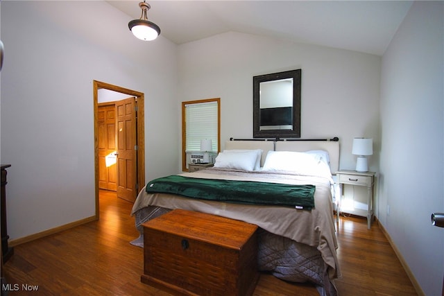 bedroom with dark hardwood / wood-style flooring and lofted ceiling