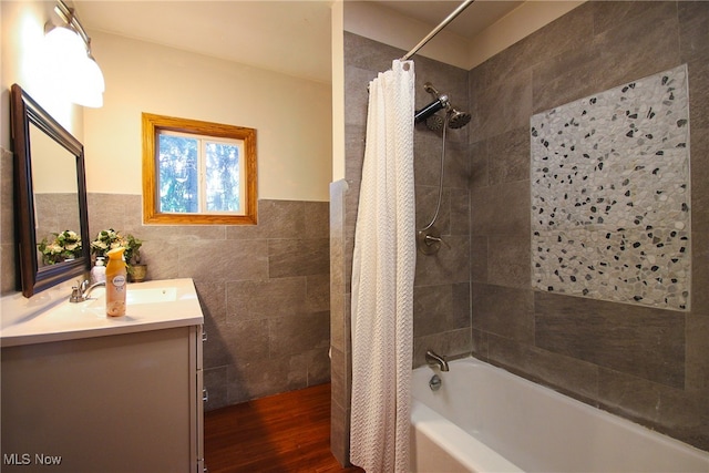 bathroom with vanity, tile walls, wood-type flooring, and shower / bath combination with curtain