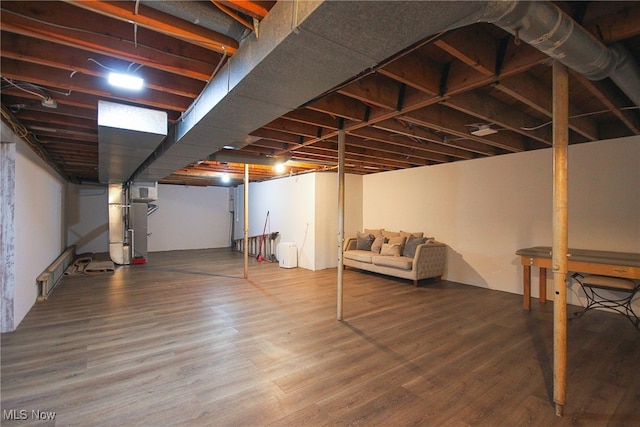 basement with heating unit and wood-type flooring