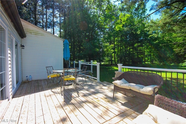 wooden terrace featuring a lawn