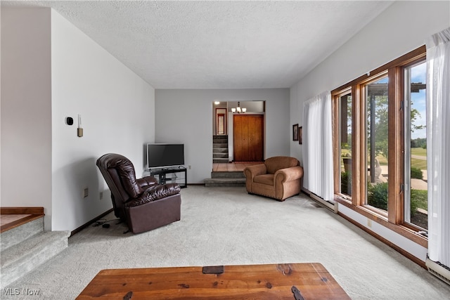 carpeted living room with a chandelier and a textured ceiling