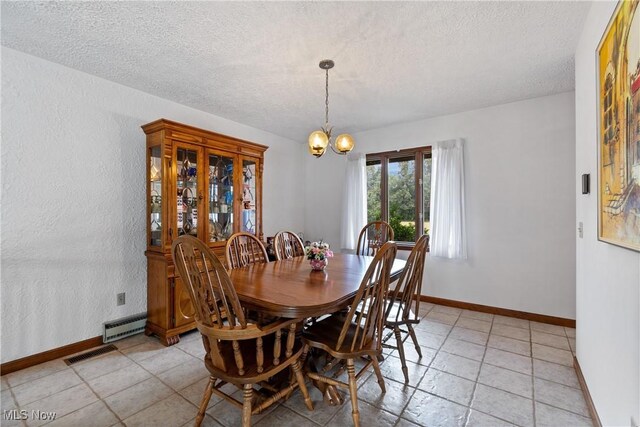 dining area with a notable chandelier, light tile patterned floors, and a textured ceiling