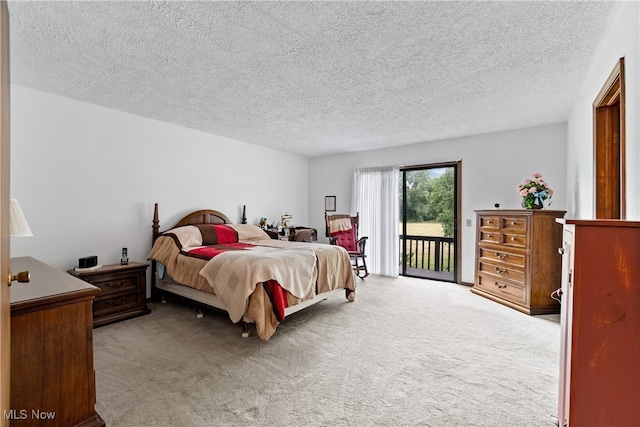 carpeted bedroom with access to outside and a textured ceiling