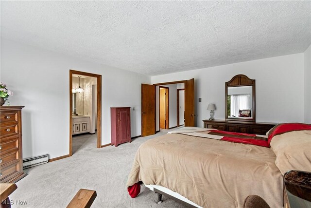 bedroom featuring a textured ceiling, baseboard heating, ensuite bath, and light colored carpet