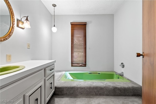 bathroom with vanity, a washtub, and a textured ceiling