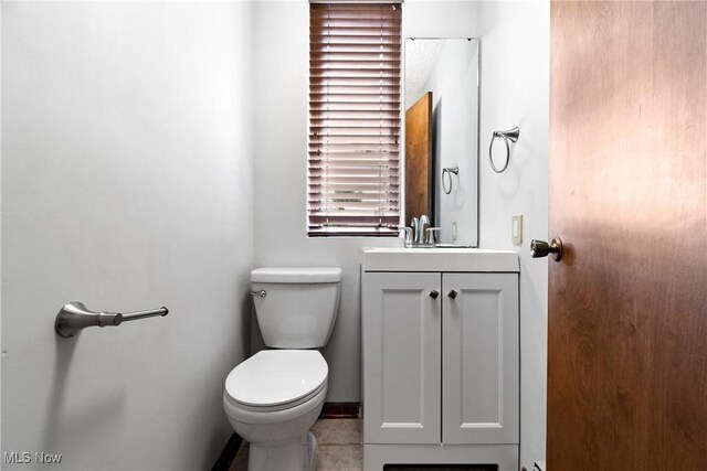 bathroom featuring vanity, toilet, and tile patterned flooring