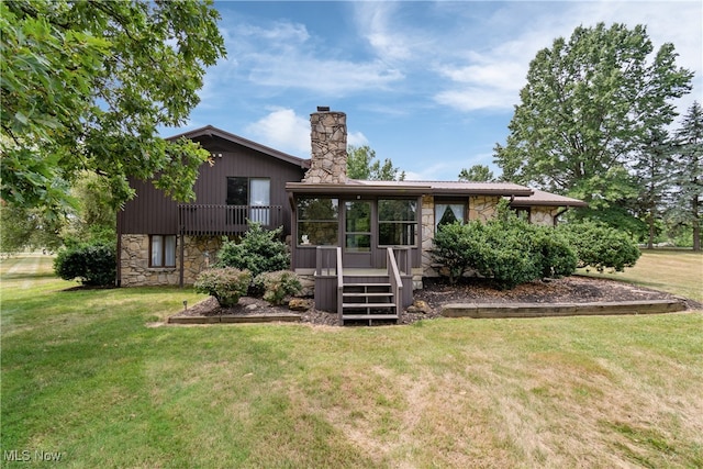 rear view of house with a yard and a wooden deck