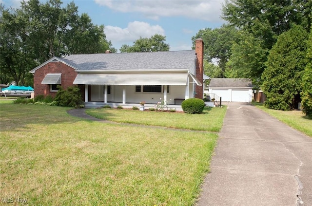 view of front of property with a porch, an outdoor structure, a garage, and a front yard