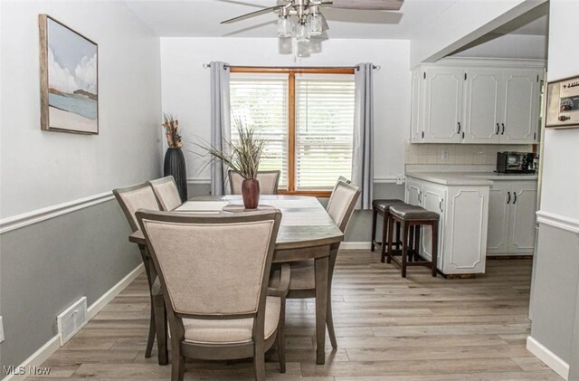 dining space with light wood-type flooring and ceiling fan