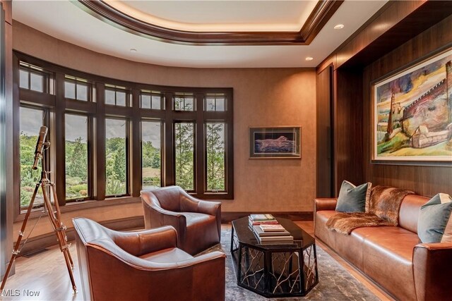 living area featuring hardwood / wood-style floors and a tray ceiling