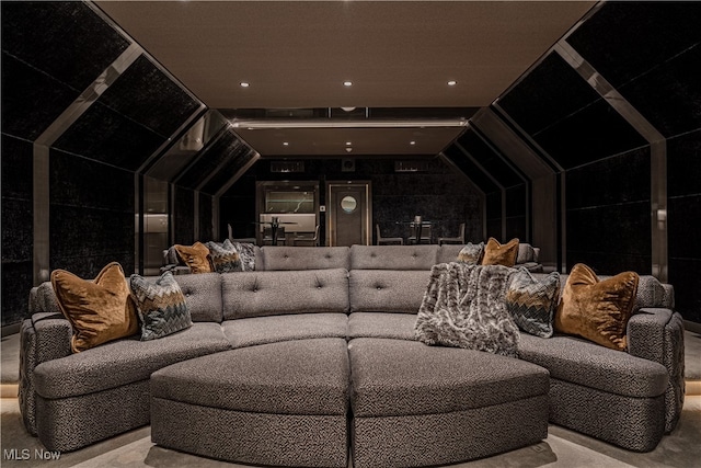 home theater room featuring lofted ceiling and light colored carpet