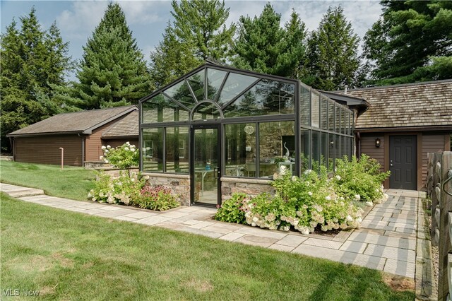 back of house featuring an outbuilding and a lawn