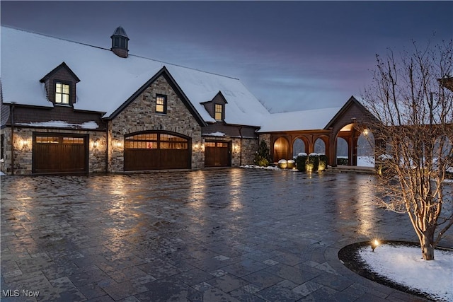 view of front of home with a garage and decorative driveway