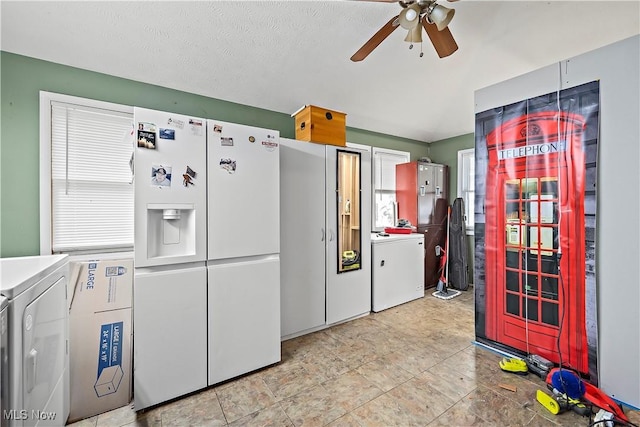 kitchen with ceiling fan, washer / dryer, white fridge with ice dispenser, and a textured ceiling