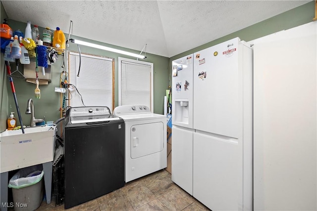 laundry area with washer and clothes dryer and a textured ceiling