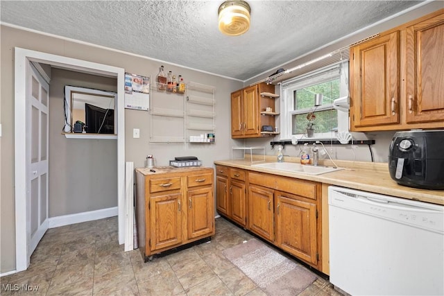 kitchen with sink, white dishwasher, and a textured ceiling