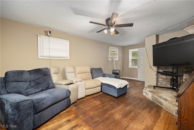 living room featuring ceiling fan and dark wood-type flooring