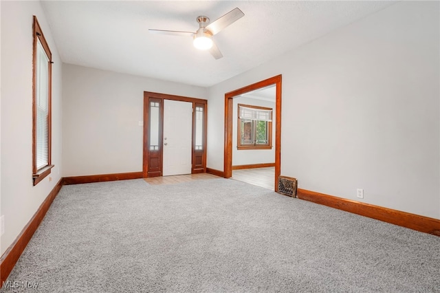 spare room featuring light colored carpet and ceiling fan