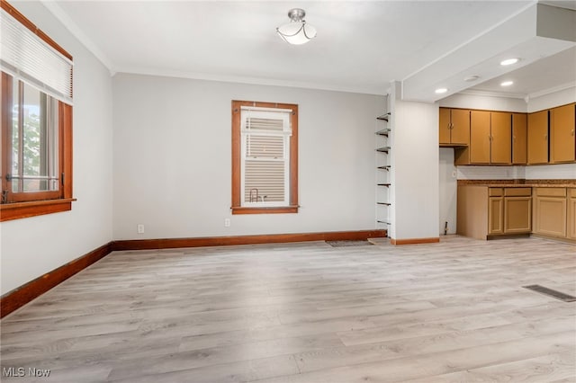 unfurnished living room with crown molding and light hardwood / wood-style flooring