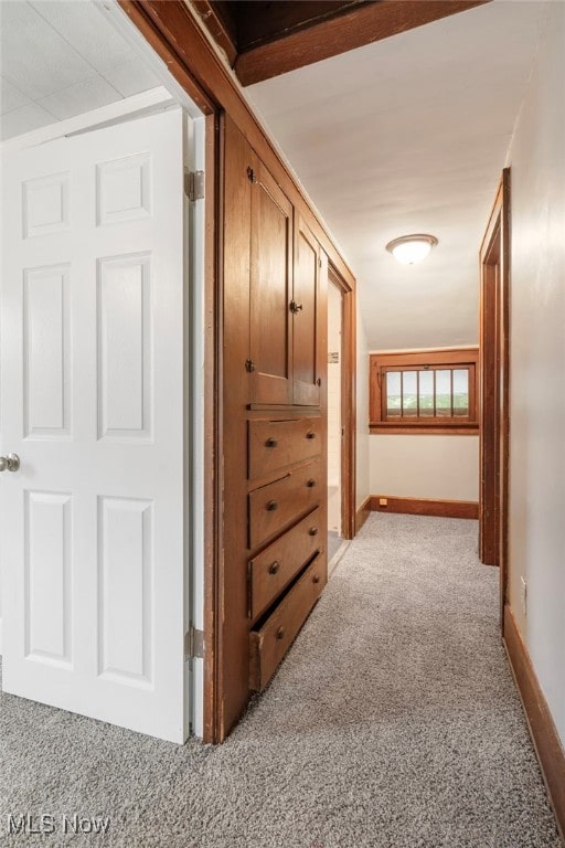 corridor featuring light colored carpet